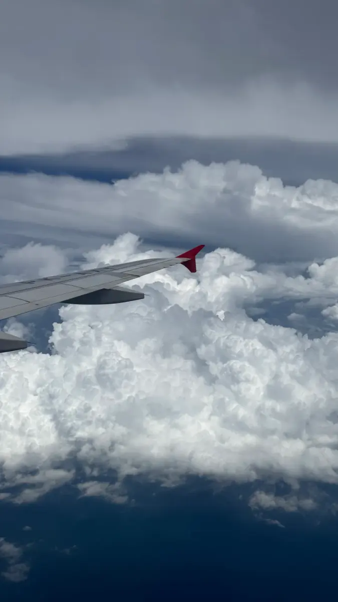 An aircraft wing above a bank of cloud